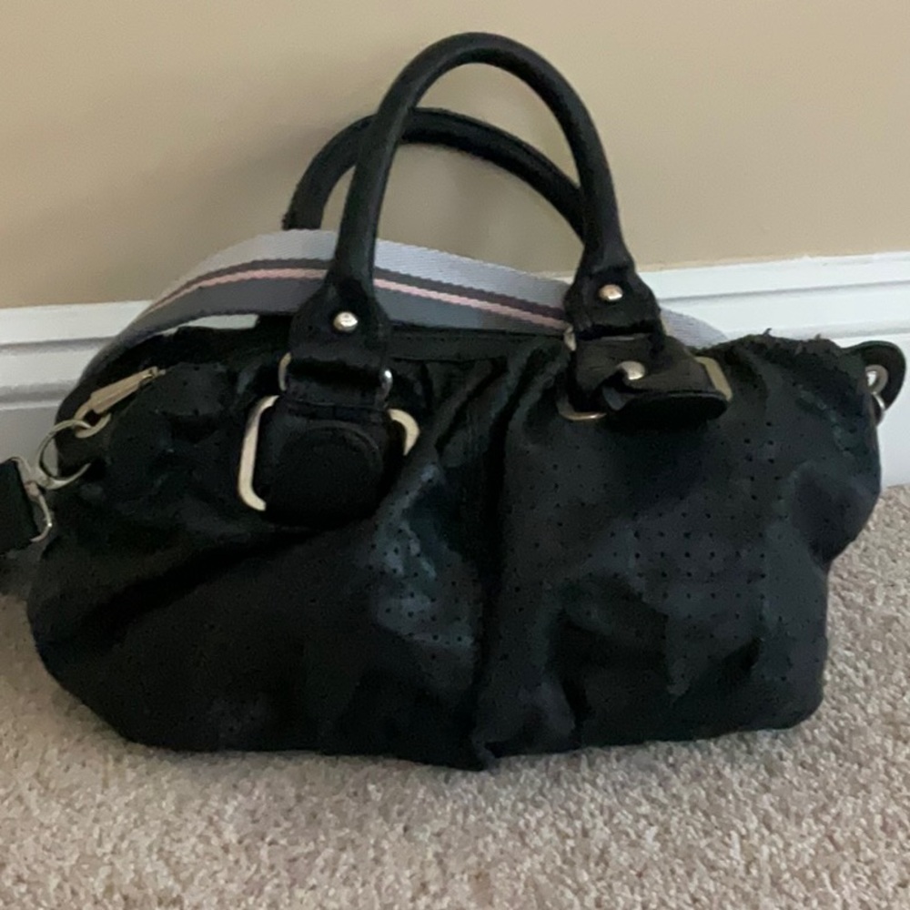 Perforated vegan leather handheld, duffel satchel, includes crossbody strap.